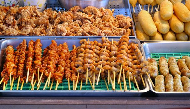 A street vendor sells fried chicken, meat skewers and corn dogs
