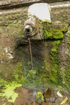 Gargoyles with holy water in the complex of royal tombs of the Udayan dynasty. Ancient royal tombs at Gunung Kawi Temple. Funeral complex centered around royal tombs carved into stone cliffs, Bali.