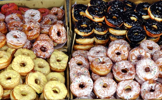 Stacks of fresh sugar frosted donuts are sold at an outdoor market