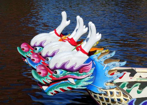 Three dragon boats with the traditional figurehead in the shape of a dragon
