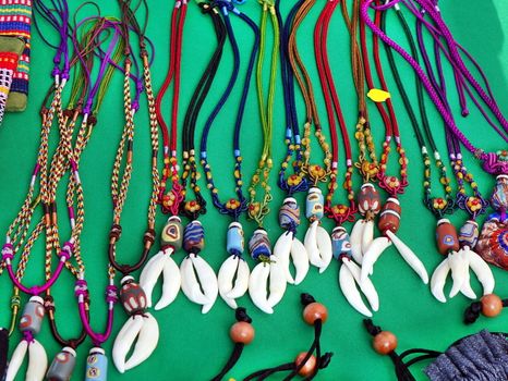 Aboriginal handmade jewelry and necklaces with colorful glass beads and animal teeth for sale at a market
