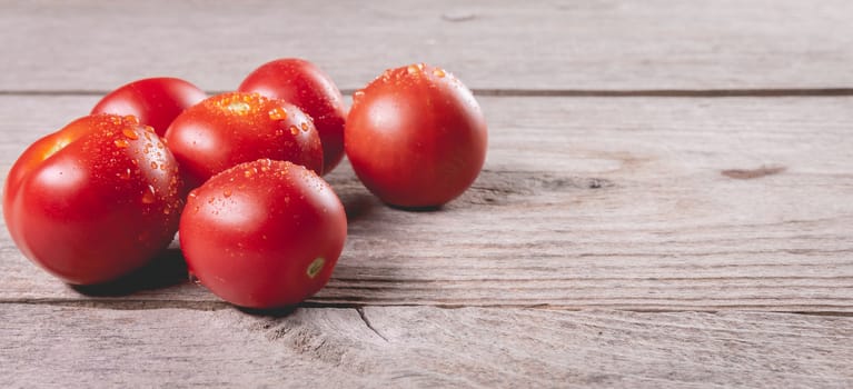 ripe tomatoes on wooden board background in studio