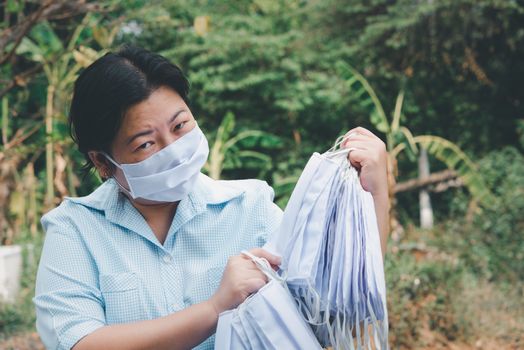 Asian pretty woman wearing mask respiratory protection mask against epidemic flu covid19 or corona virus influenza in office with fear emotion in concept illness, outbreak, healthcare in life