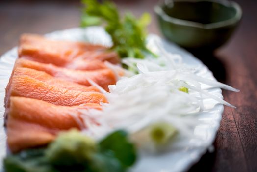 Japanese food delicacy consisting sashimi salmon of very fresh raw salmon fish sliced into thin pieces serving with radish sliced in japan restaurant