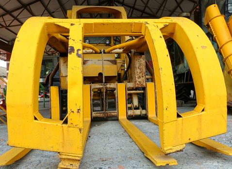 Vintage obsolete agricultural harvesting machine in bright yellow
