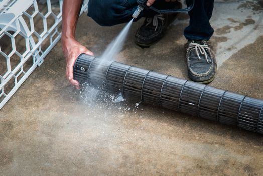 Worker to cleaning coil cooler of air conditioner by water for clean a dust on the wall in customer home when maintenance service