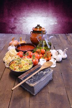 Cookbook over the kitchen table with ingredients.