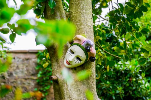 human face baked clay mask on a tree in a garden UK