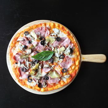Pizza with dry cured ham and basil