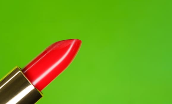 Beautiful bright red lipstick and green complementary color on the background.