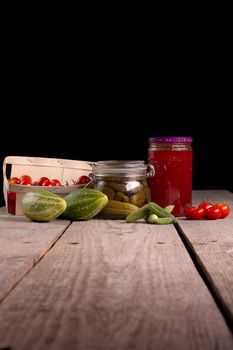 cucumber tomatoes cherry tomato jam canned corinichons on wooden background in studio