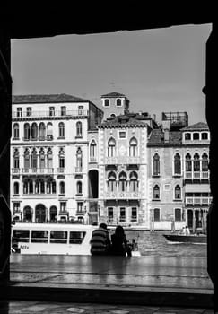 Couple sitting and looking at the Gran Canal in Venezia. Black and white image