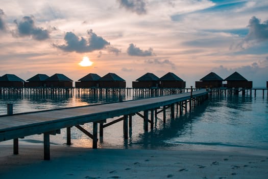 Beautiful sunset with water bungalows or water villas at Maldives