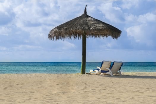 Two Beach chairs on the white sand beach. It could be any place of Maldives, Indian ocean, Pacific ocean, Bahamas, Hawaii or caribbean sea.