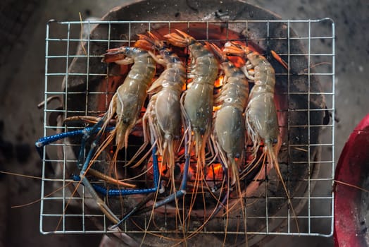 Grilled shrimp (Giant freshwater prawn) grilling with charcoal for sale at Thai street food market or restaurant in Bangkok Thailand