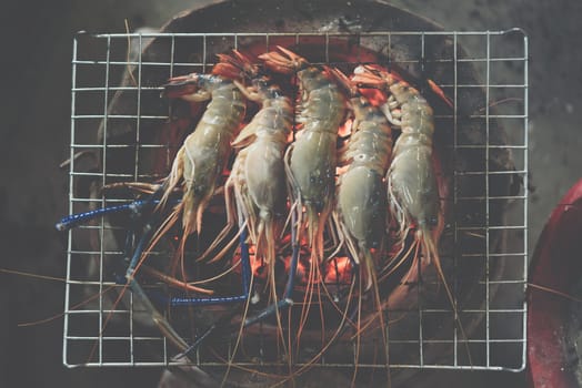 Grilled shrimp (Giant freshwater prawn) grilling with charcoal for sale at Thai street food market or restaurant in Bangkok Thailand