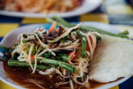 Papaya salad or Papaya Pok Pok (Som tum) for sale at Thai street food market or restaurant in Thailand