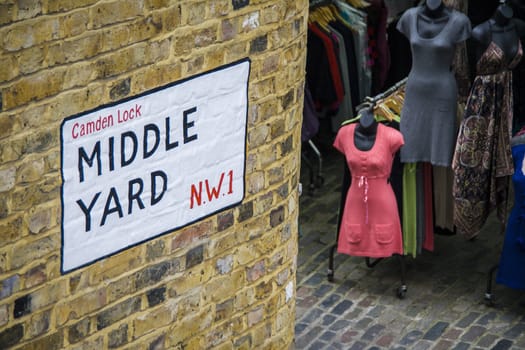 Middle Yard Street sign on a bricked wall in Camden lock market. Famous alternative culture shops in Camden Town, London.