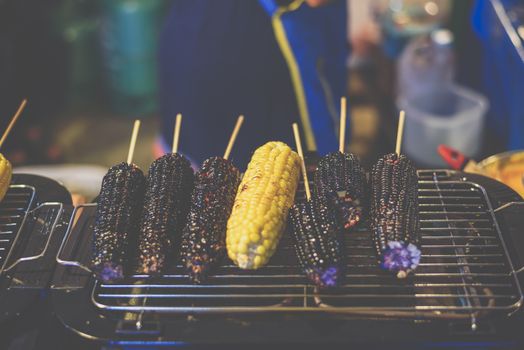 Roasted or Grilled Corn and Purple Corn (Black Glutinous Corn) for sale at Thai street food market or restaurant in Thailand