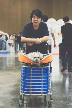 Asian woman feeling happy when her and her pet (The dog) on shopping cart allowed to entrance for exhibit hall or expo