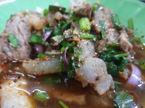 Spicy minced beef salad or Ground beef salad (Laab) is a Thai food for health consists of beef, ground rice, chili, lemon, onion and herb mixed in plate on a wood table at Thai street food