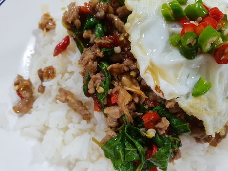 Rice topped with stir-fried pork or beef and basil for sale at Thai street food market or restaurant in Bangkok Thailand