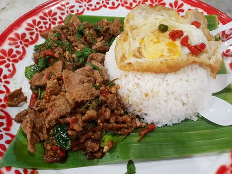 Rice topped with stir-fried pork or beef and basil for sale at Thai street food market or restaurant in Bangkok Thailand