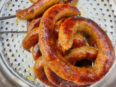 Roasted or Grilled Notrhern Thai Spicy Sausage (Sai Aua) for sale at Thai street food market or restaurant in Thailand