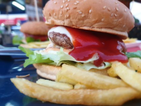 Hamburger is a fast food make from bun, meat, cheese and vegetable  in fastfood restaurant, unhealthy food or fat concept