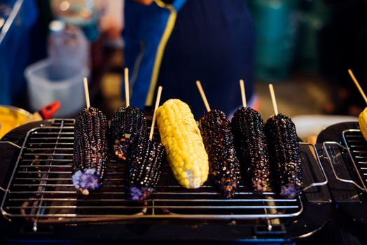 Roasted or Grilled Corn and Purple Corn (Black Glutinous Corn) for sale at Thai street food market or restaurant in Thailand