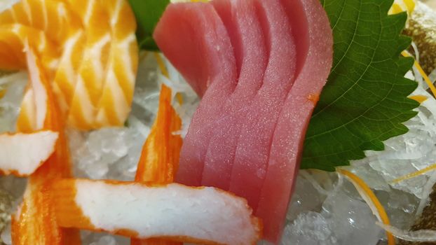 Japanese food delicacy consisting sashimi salmon of very fresh raw salmon fish sliced into thin pieces serving with radish sliced in japanese restaurant