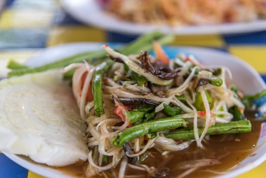 Papaya salad or Papaya Pok Pok (Som tum) for sale at Thai street food market or restaurant in Thailand