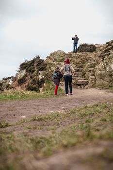 Howth near Dublin, Ireland - February 15, 2019: walkers walking on a hiking path on the cliff skirting the sea in Howth, Ireland