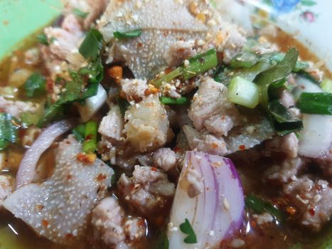 Spicy minced beef salad or Ground beef salad (Laab) is a Thai food for health consists of beef, ground rice, chili, lemon, onion and herb mixed in plate on a wood table at Thai street food