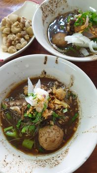 Braised beef clear noodle with meat balls soup stew (Ekaehla meat) with vegetable in bowl for sale at Thai street food market or restaurant in Thailand