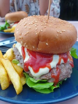 Hamburger is a fast food make from bun, meat, cheese and vegetable  in fastfood restaurant, unhealthy food or fat concept