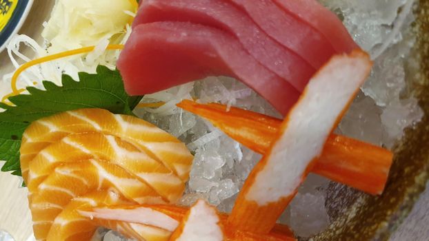 Japanese food delicacy consisting sashimi salmon of very fresh raw salmon fish sliced into thin pieces serving with radish sliced in japanese restaurant