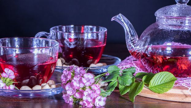 Red hot hibiscus tea in glass mug. Tea time: cup of tea, carcade, karkade, rooibos. Oriental, cozy, ceremony, tradition, japanese, leafy, hygge, autumn, 5 o'clock, afternoon tea