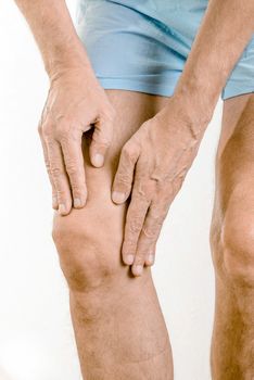 Athlete man massaging a painful  quadriceps and the knee after a sport accident. It could be a quadriceps tendinopathy, a muscle elongation, a medial meniscus tears or bursitis