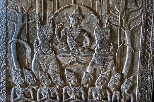Ancient Khmer bas relief carving showing the Hindu god Vishnu riding on a chariot pulled by a pair of horses. Angkor Wat temple, Siem Reap, Cambodia.