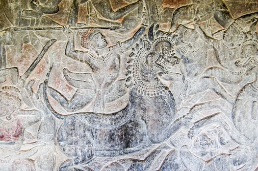 Ancient Khmer carving of a Hindu god riding into battle on the back of an imperial lion. Bas relief frieze on a wall of Angkor Wat Temple, Siem Reap, Cambodia.