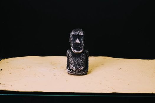 A mock statue from Easter Island. A stone man on the sand.
