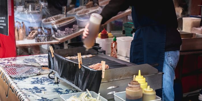 Dublin, Ireland - February 16, 2019: Live food stall where a cook prepares a meal in front of his client in the Temple Bar district on a winter day