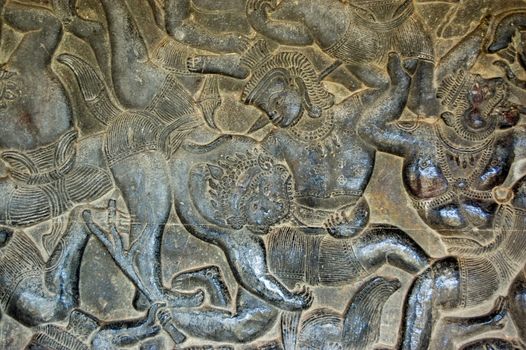 Ancient Khmer bas relief carving showing a monkey soldier in the Hanuman army biting a demon in the Battle of Lanka as recounted in the Ramayana. Angkor Wat temple, Cambodia.