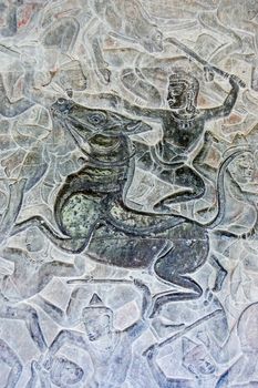 Ancient Khmer bas relief carving showing a Hindu god riding a horse into battle. Wall of Angkor Wat temple, Siem Reap, Cambodia.