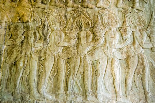 Bas relief carving of a procession of gods bearing gifts for Vishnu on a wall in the North West corner of Angkor Wat temple showing scenes from the Ramayana.  Cambodia.