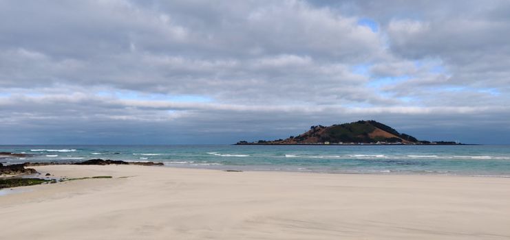 Landscape of Hyeopjae beach with sand, mountain and cobalt blue sea in Jeju Island, South Korea