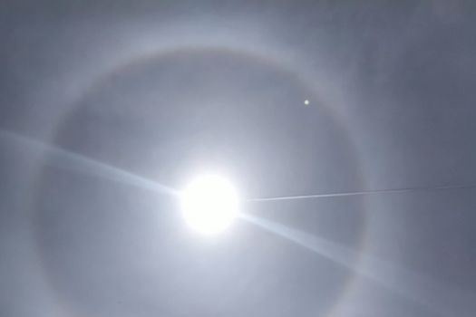 The phenomenon of halo in the sky. A rare natural phenomenon. Three halo suns. The plane flies through the halo.