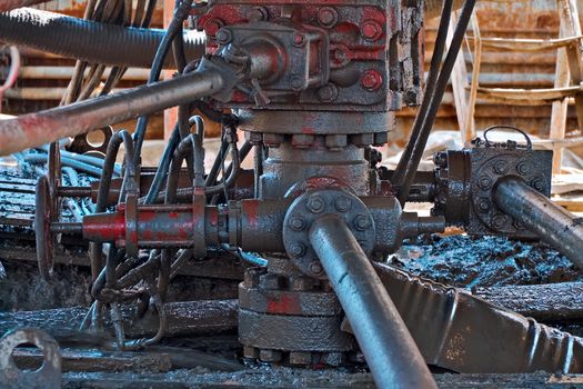 Dirty well during repair work. Oil and dirt on the equipment of the oil well.