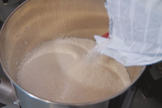 Pouring polymer granules into a steel tank. Making explosives.